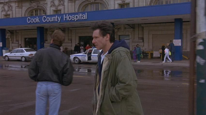 A Fugitve movie still of Harrison Ford as Richard Kimble walking passed the Old Cook Coubty Hospital marquee