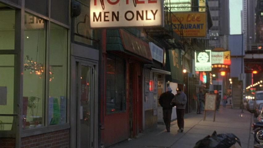 A The Fugitive movie still of a city street at dusk with a Hotel Men Only sign