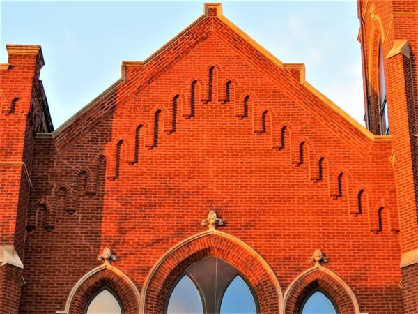 A red brick church gable in evening sun.