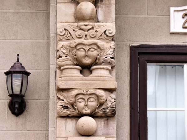 A terra cotta building detail of female faces.