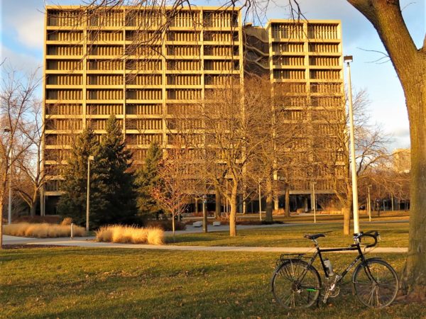 A tour bike and leafless trees in front of Brutalist style Science & Engineering Offices at UIC.