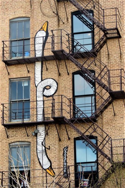 A two headed goose neck mural by Goosenek and fire escape of the Lacuna Building.