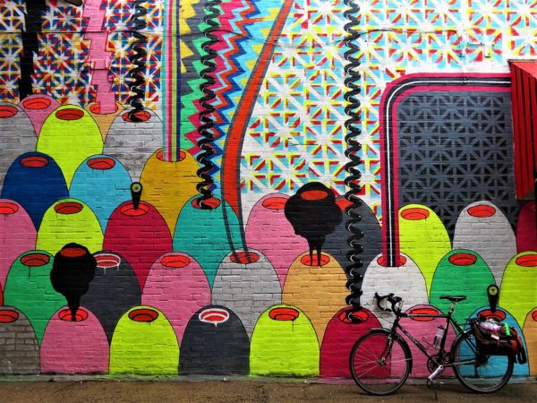Bike leaning on multicolored mural.