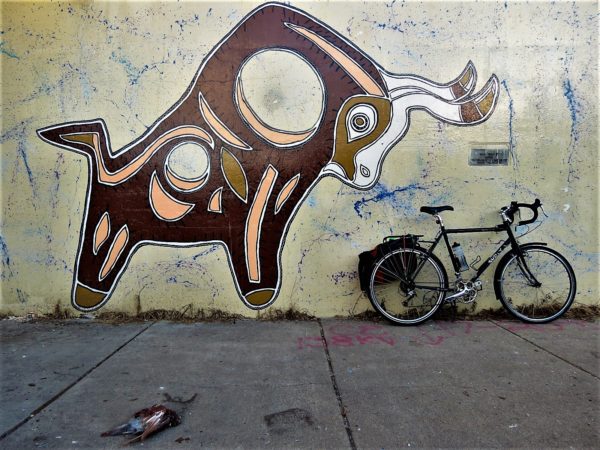 Bicycle leaning on a bull themed mural.