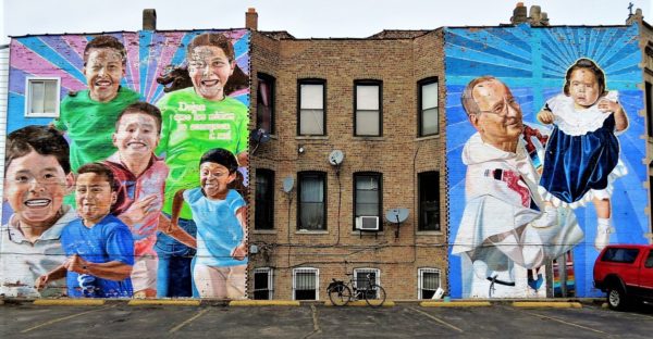 A bike between two community themed murals during a tour ride