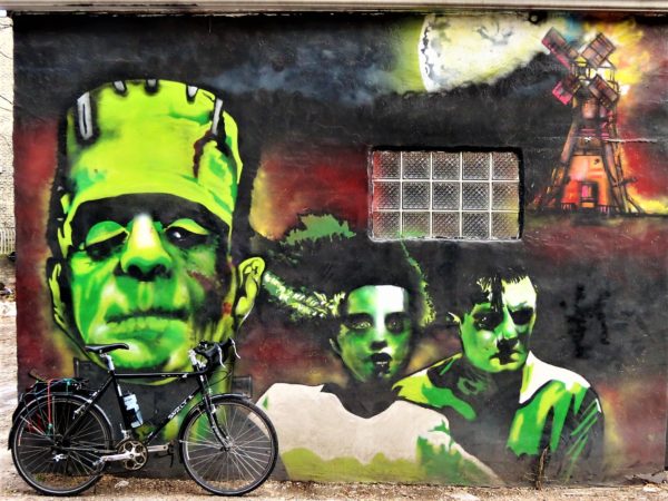 Frankenstein's monster and bride mural with a leaning bicycle.