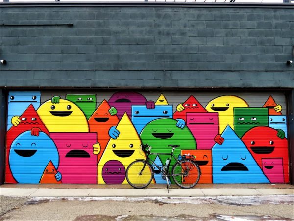 Bicycle in front of geometric characters mural during a tour ride.