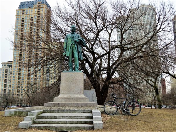 1800s Illinois Governor statue in park with a bicycle during a tour ride.