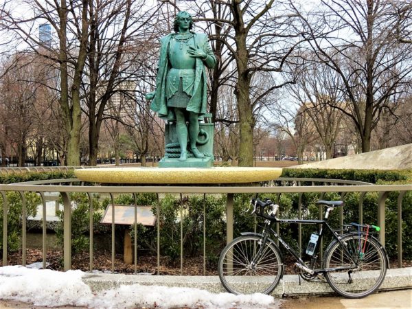 Statue in a park with a bicycle during a tour ride.