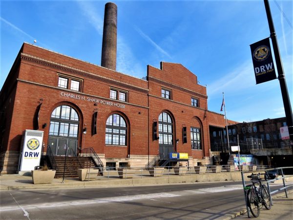 A tour bike and red brick large arched window Charles Show Power House high school.