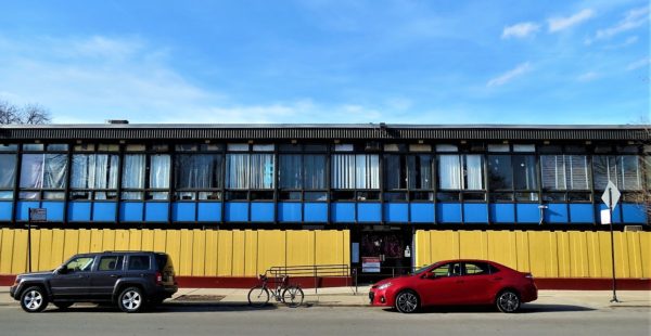 Mid-century modern building with red, yellow and blue horizontal color and a bike during a tour ride.