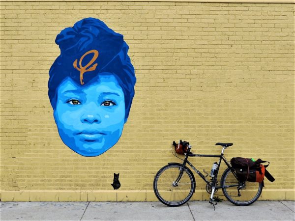 Blue wheat paste of turbaned head with a bicycle during a tour ride.