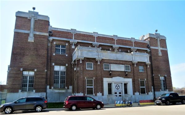 Art Deco red brick municipal building with a tour bike in the front.