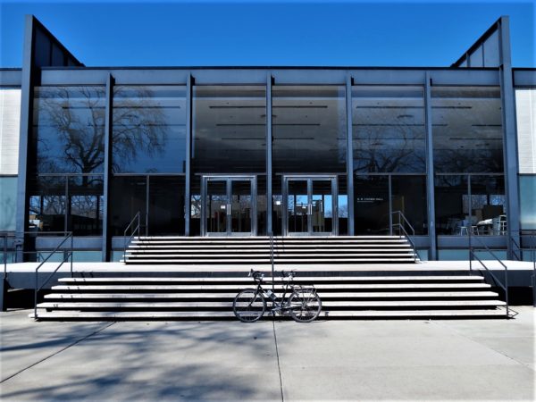 A tour bike standing at the front steps of the block steel and glass International Style Crown Hall building.