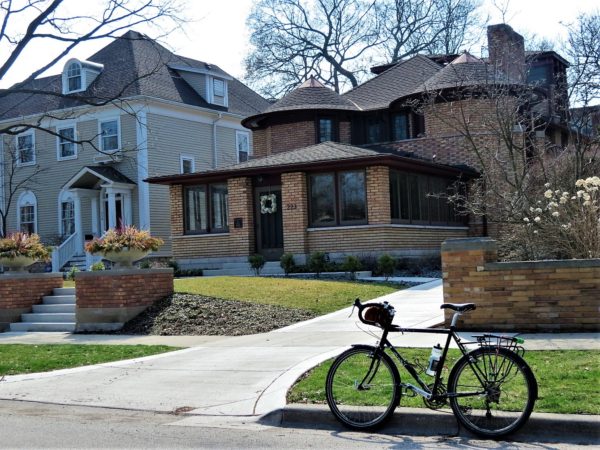 Two story brick Prairie style home with tour bike.
