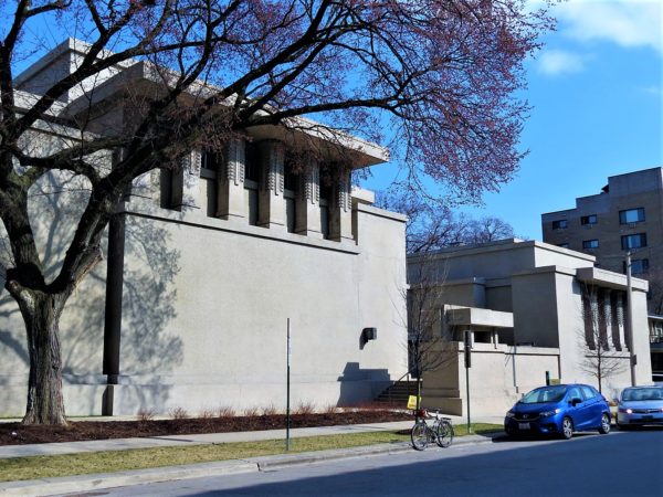 A tour bicycle in front of a stucco Prairie style church