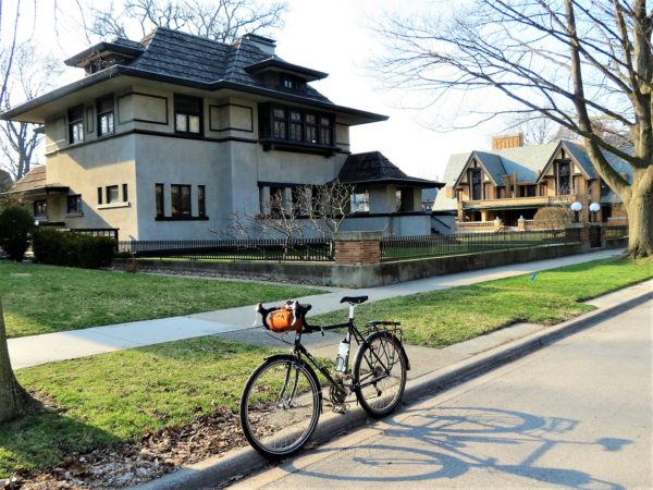 Three story stucco Prairie style home with tour bike.