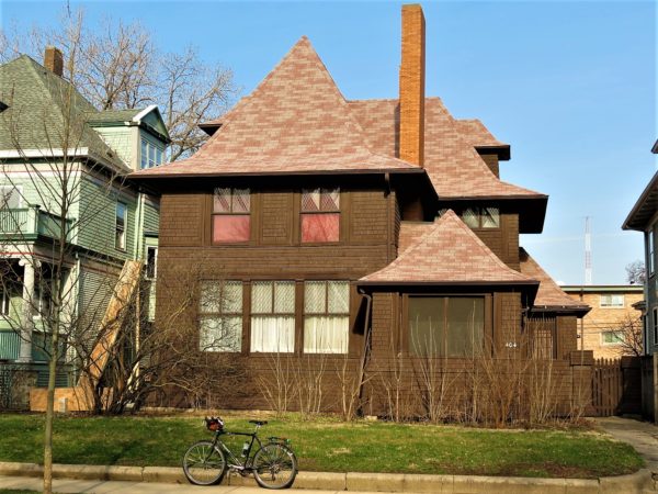 Brown painted wood with low roofs and tour bike in front.