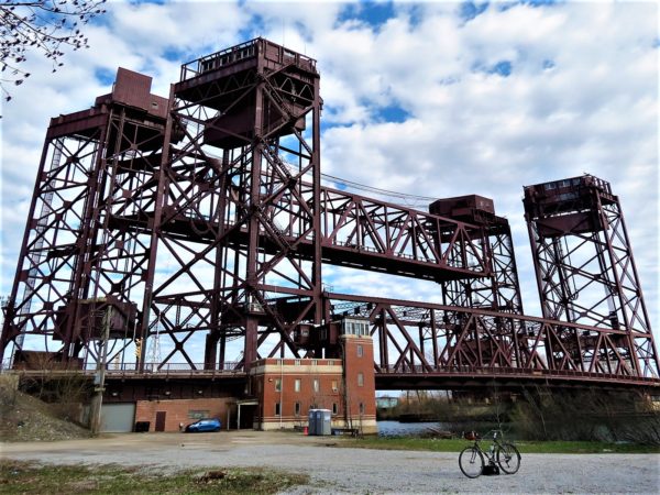 Vertical lift bridges with a standing tour bicycle in front.