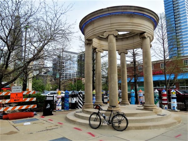 Greektown columns/lighthouses and a tour bike atanding in front.