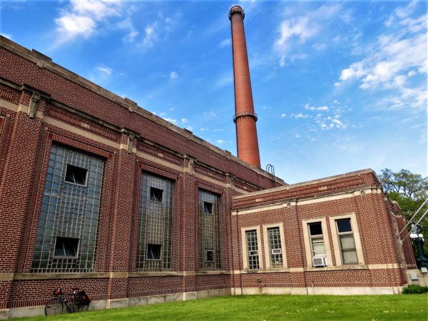 Red brick art deco building with smokestack and a leaning tour bike