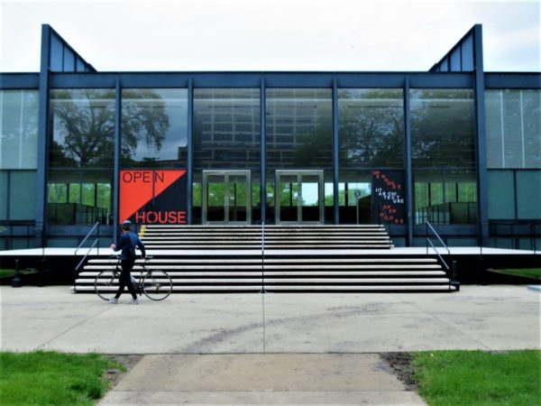 A CBA bike tour rider getting a closer look at the Modernist glass and black steel Ludwig Mies van der Rohe designed Crown Hall at IIT.