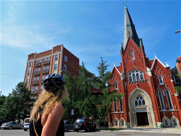 A CBA bike tour ride looking at a red and cream brick Neo-gothic church