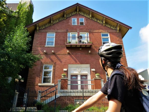 A CBA bike tour rider looking at a two and a half story building with a gabled roof and gold dragon design