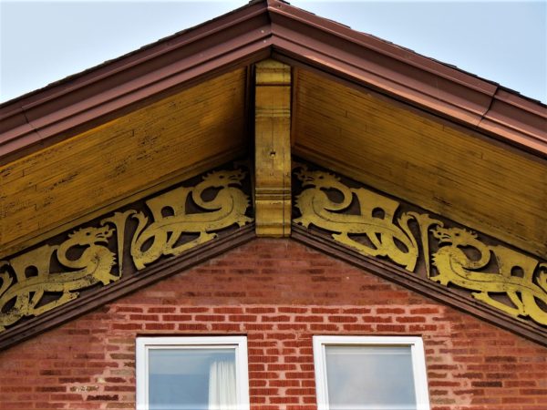 Gable with gold dragon design on brown.