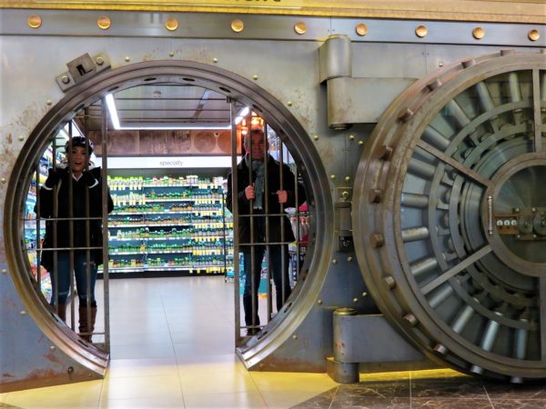 CBA bike tour riders posing in a former bank vault with vitamins inside