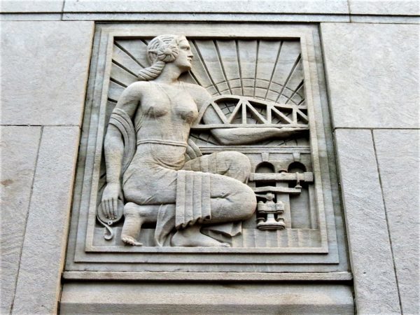 A bas relief of a women kneeling next to bridge