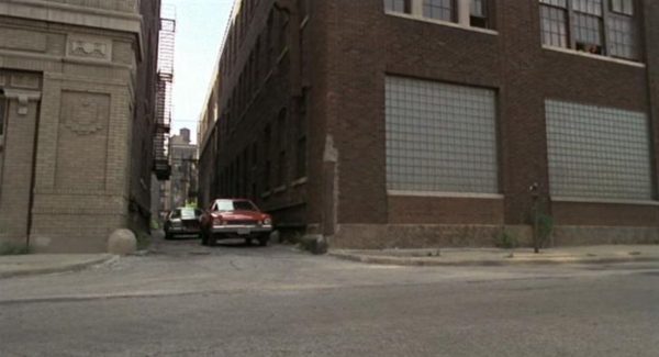 A Blues Brothers movie still of a red pinto pulling out of an alley