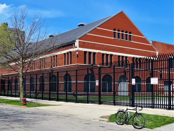 A tour bike standing in front of a red brick and white terra cotta detail city building.