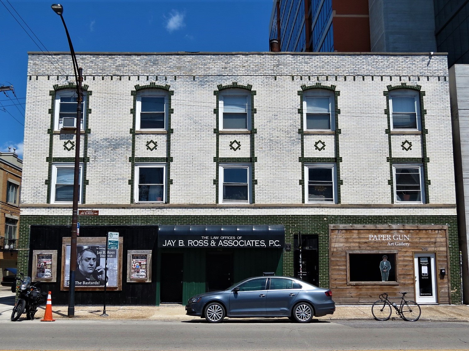 A tour bike standing in front of a three story green and white glazed brick building