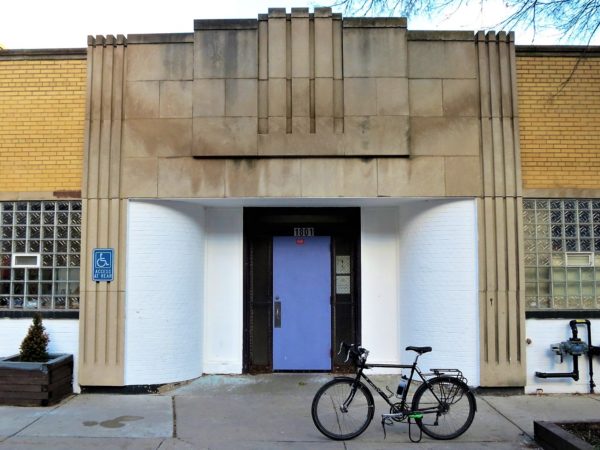 A tour bike standing in front of an Art deco grey limestone facade