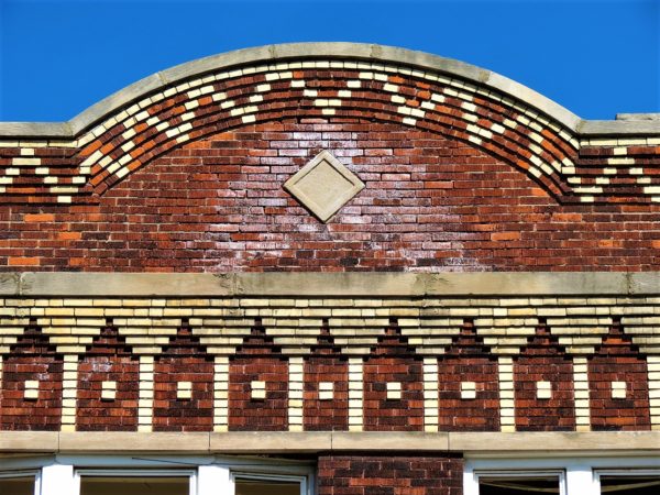 A detail tan brickwork design on red brick