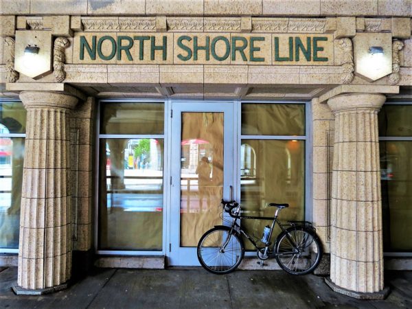 A tour bike standing in front of a Beaux Arts terra cotta train station facade.