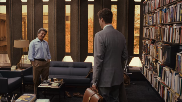 A movie still of Dustin Hoffman having a conversation with Will Ferrell in Brutalist style university office.