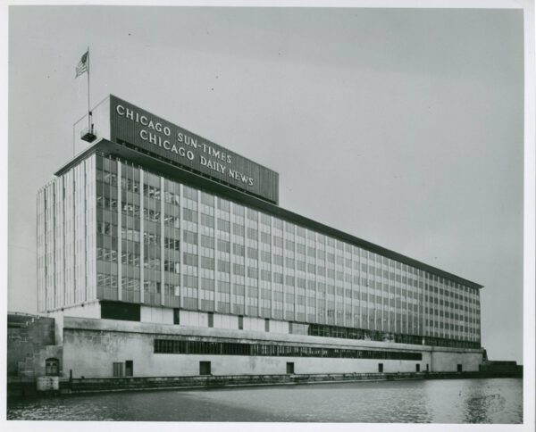 A historical black and white of the shoebox six story International Style Chicago Sun-Times building on the Chicago River.