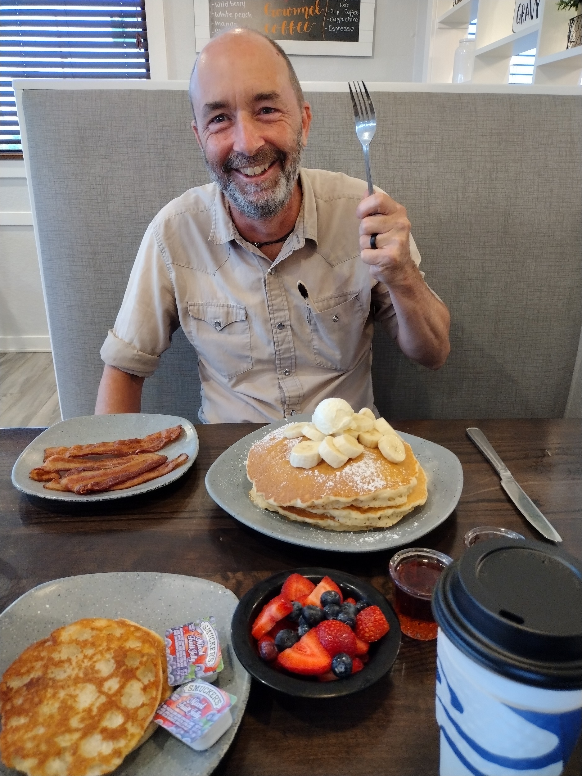 Me holding up a fork over a large stack of pancakes.