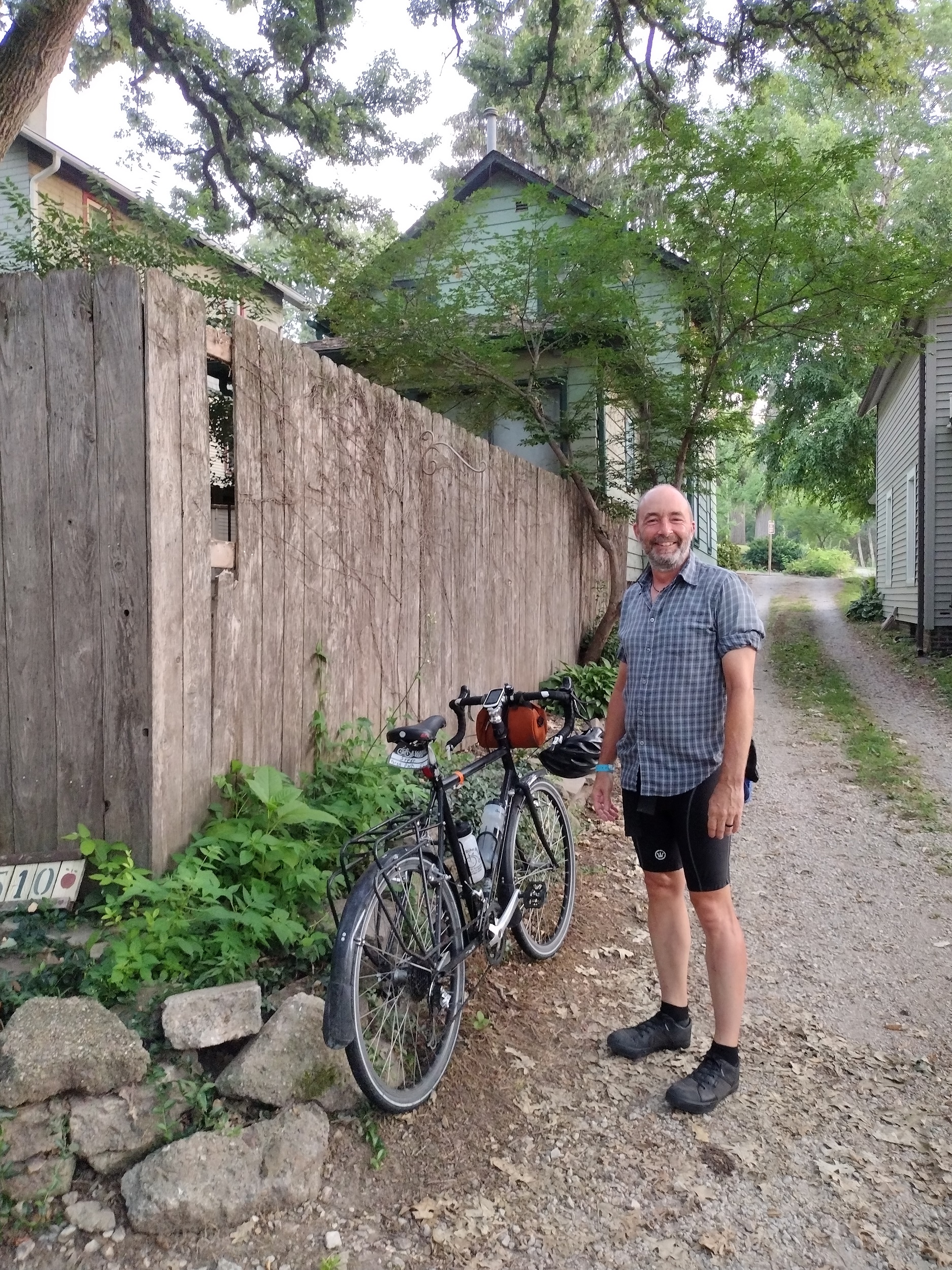 Me standing in next to my tour bike on a dirt drive.