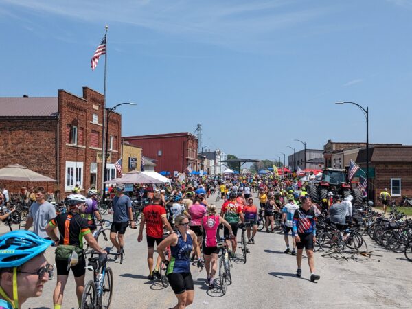 A crowd of walking cyclists in a small town main street