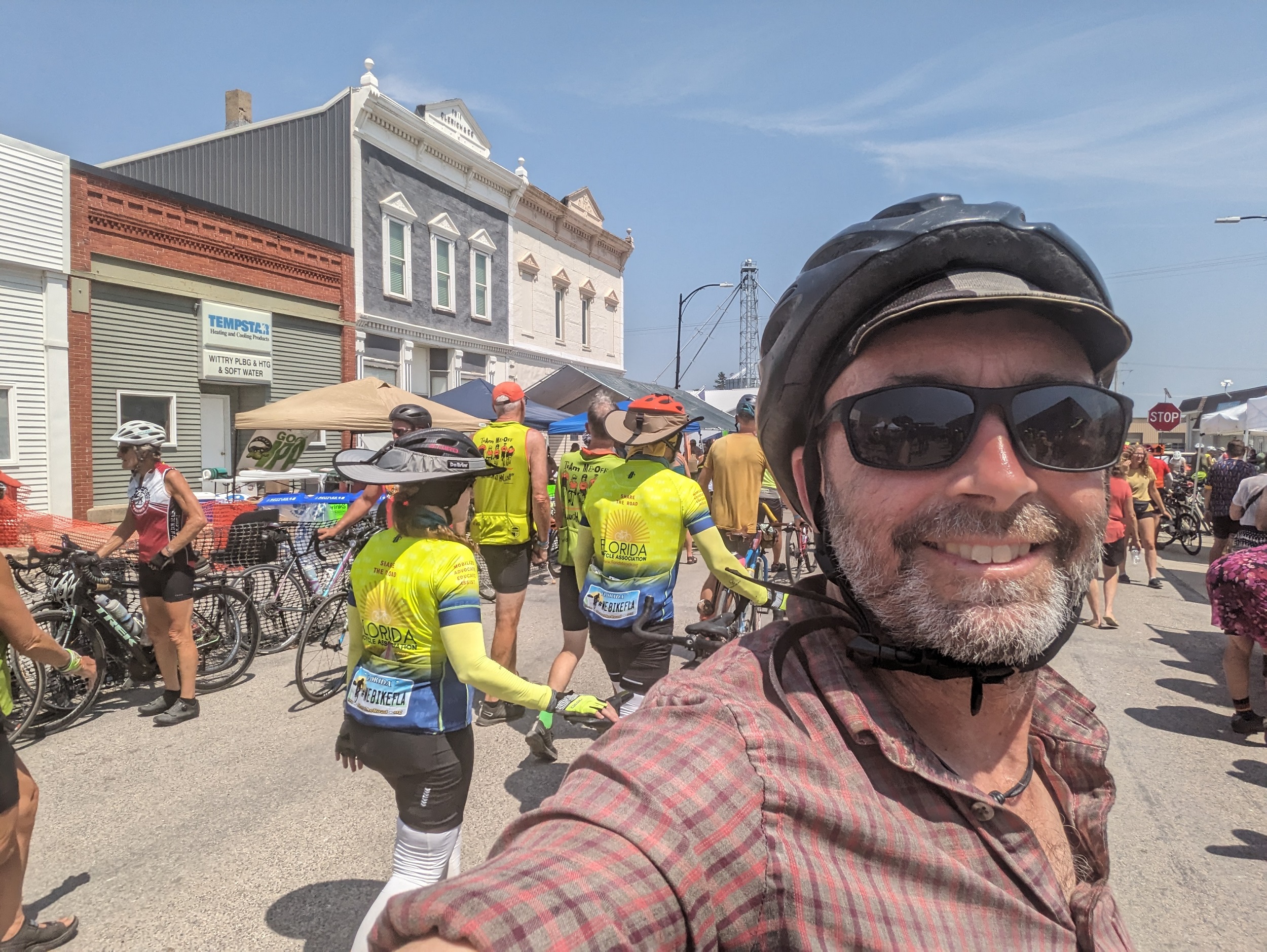 Me, cyclists, with two story 19th century wood storefronts in the background.