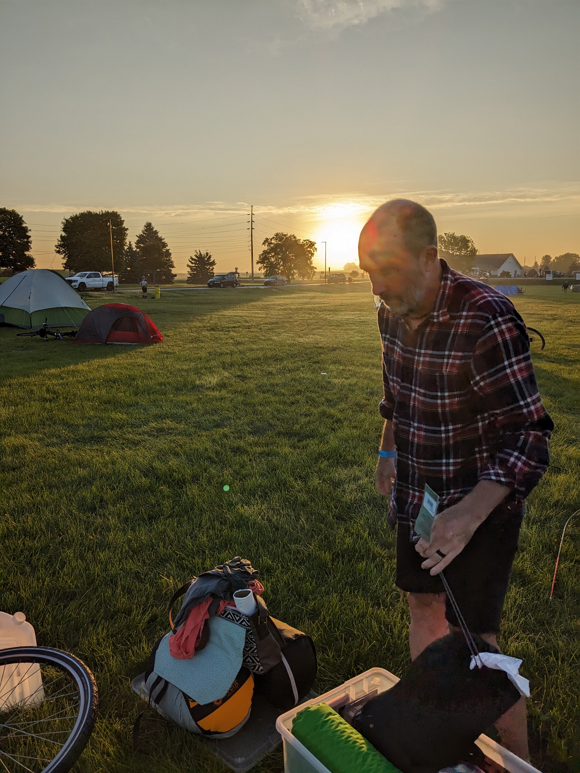 Me looking down with tents around and the rising sun behind my head.