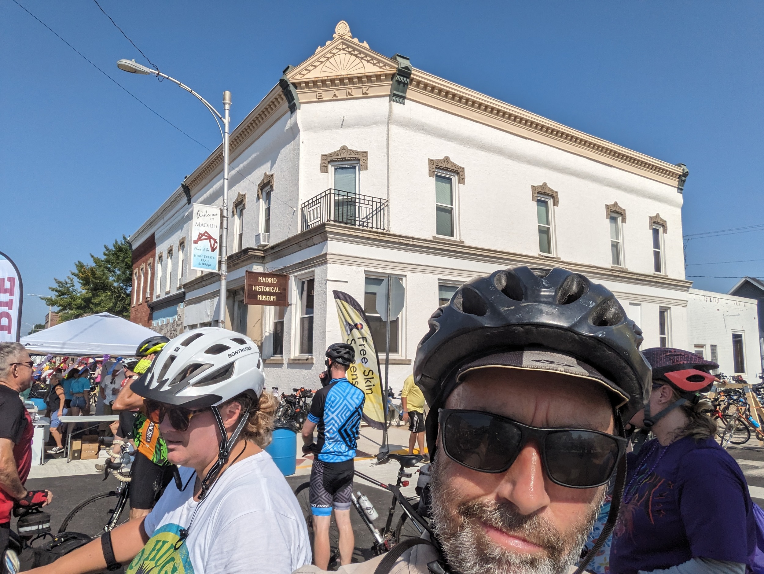 Me fake grimacing with a late 19th Century corner bank building painted white and trimmed beige.