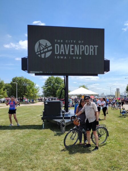 Me and Nitya looking posing for the camera below an electronic sign that says "The City of Davenport"