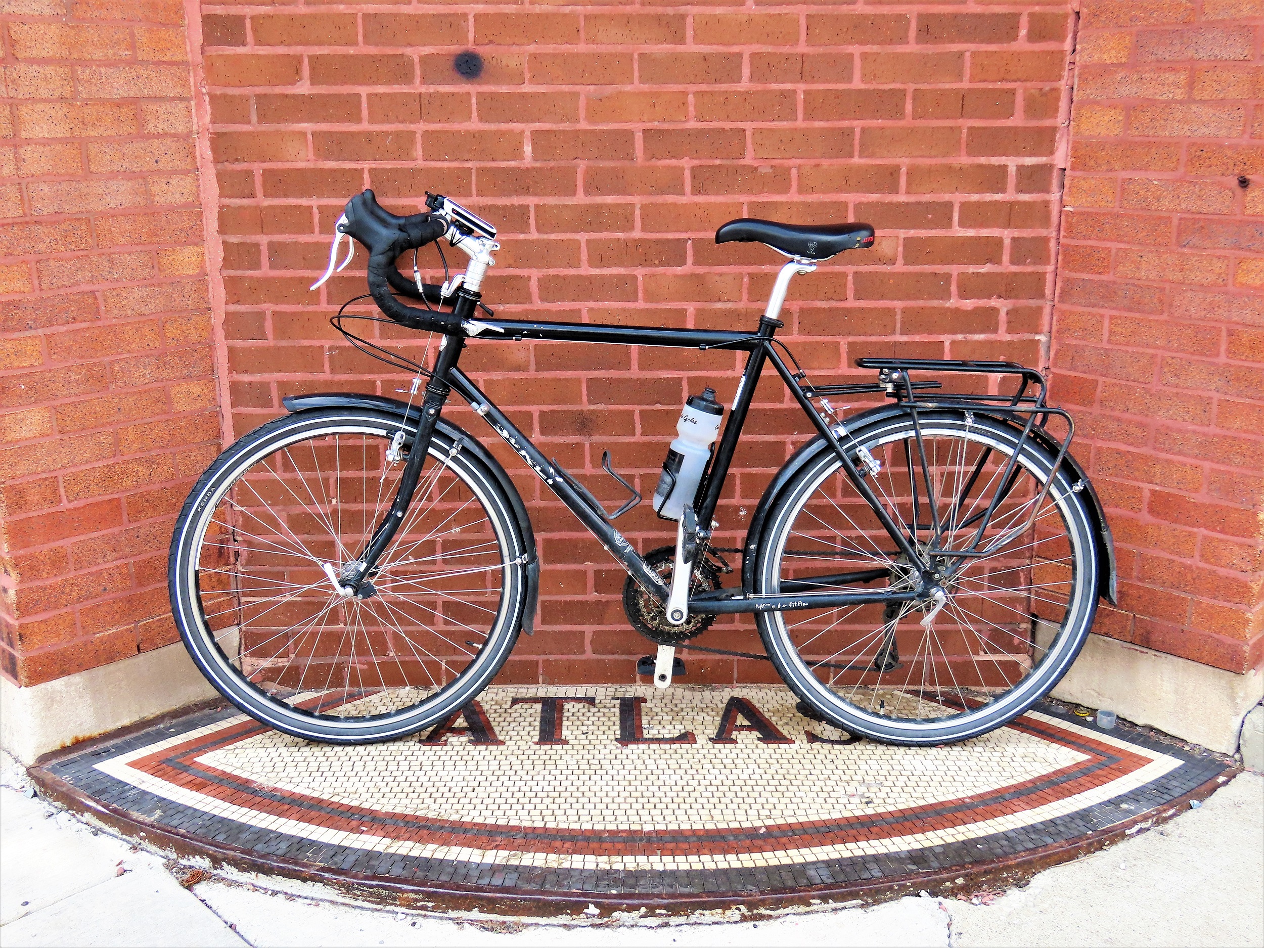 A tour bike standing on an Atlas entrance mosaic to a bricked up entry