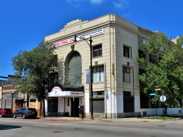 A three story building with limestone facade and three story arched entry way.
