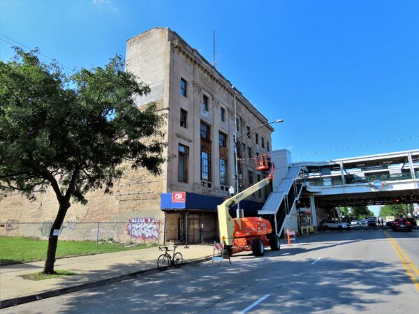 A tour bike standing at the curb in front of an abandoned looking Classical Revival four story former bank.