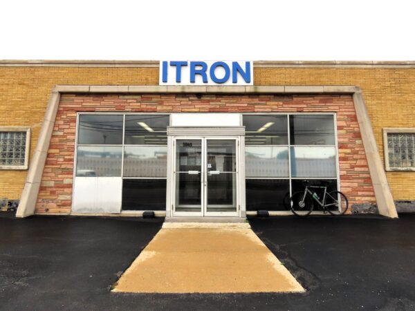 a tour bicycle leaning on the front of a multi brick textured Mid Century Modern industrial business office.